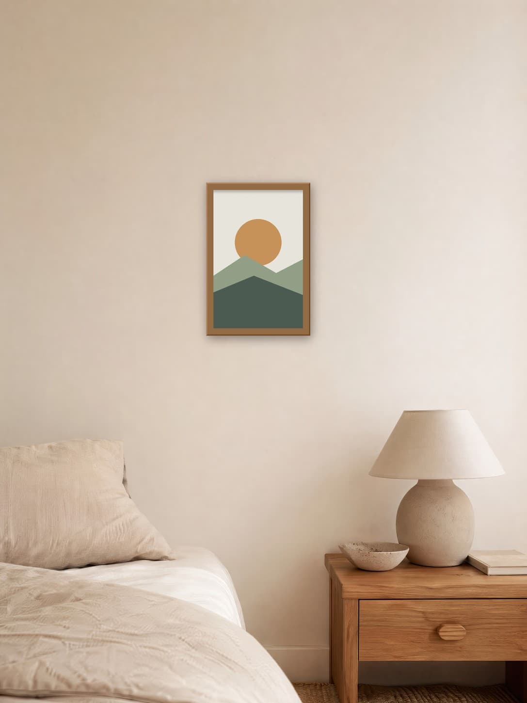 Sage and ochre landscape poster in a thin oak frame on a linen bedroom wall above a nightstand lamp