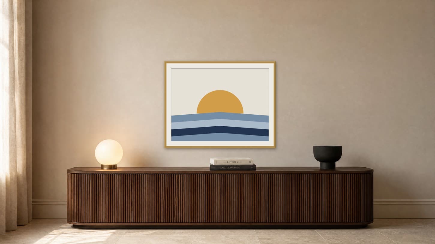 Navy and gold half-sun landscape print with a pale mat in a brass frame above a long walnut console