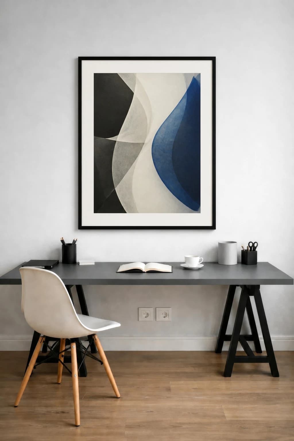 Cobalt paper-form abstract in a black frame above a minimalist home office desk