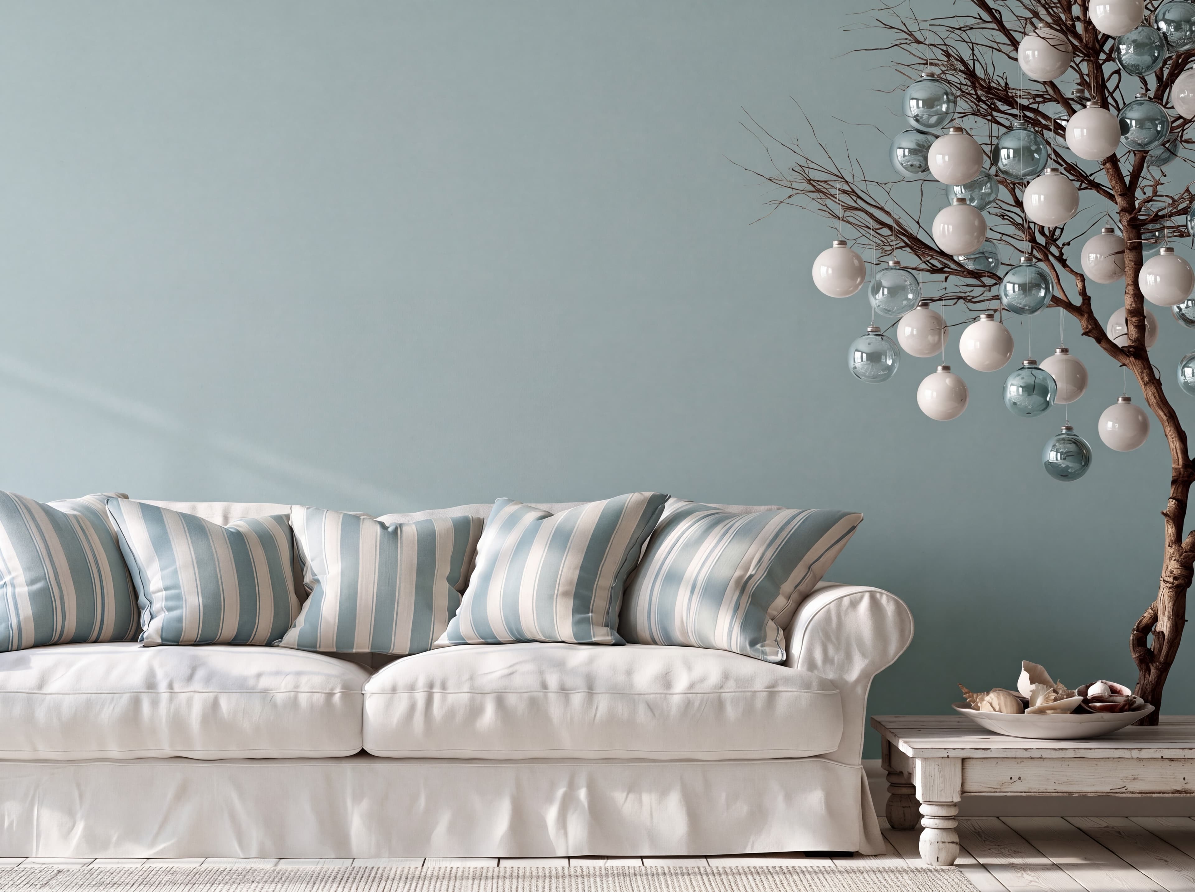Coastal Christmas living room with a pale aqua wall, white slipcovered sofa, striped cushions, and driftwood ornament tree, ranked 19 among christmas mockups