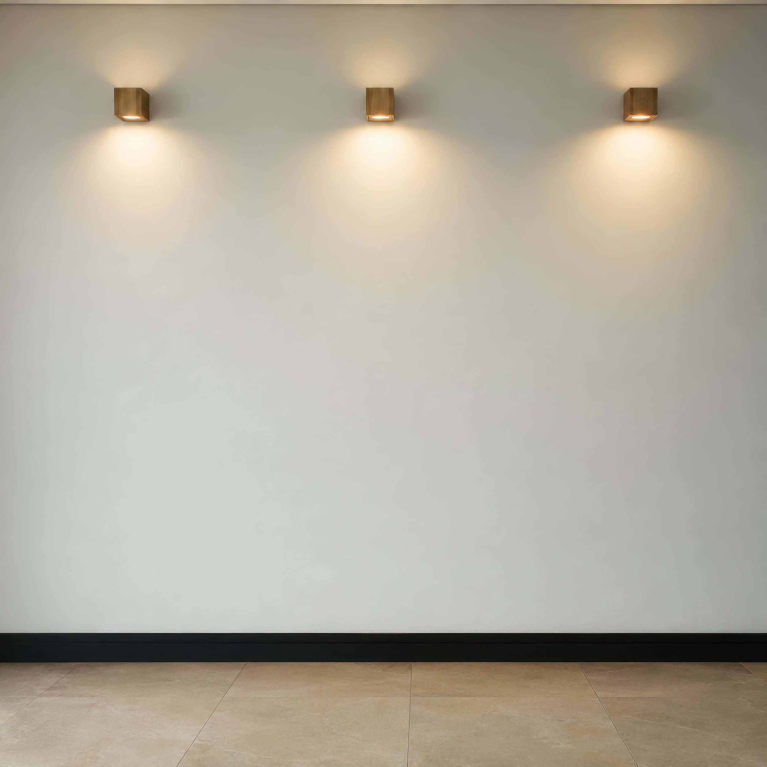Minimal gallery wall with an empty pale gray plaster surface, three warm sconces, black baseboard, and beige tiled floor, ranked 15 among exhibition mockups