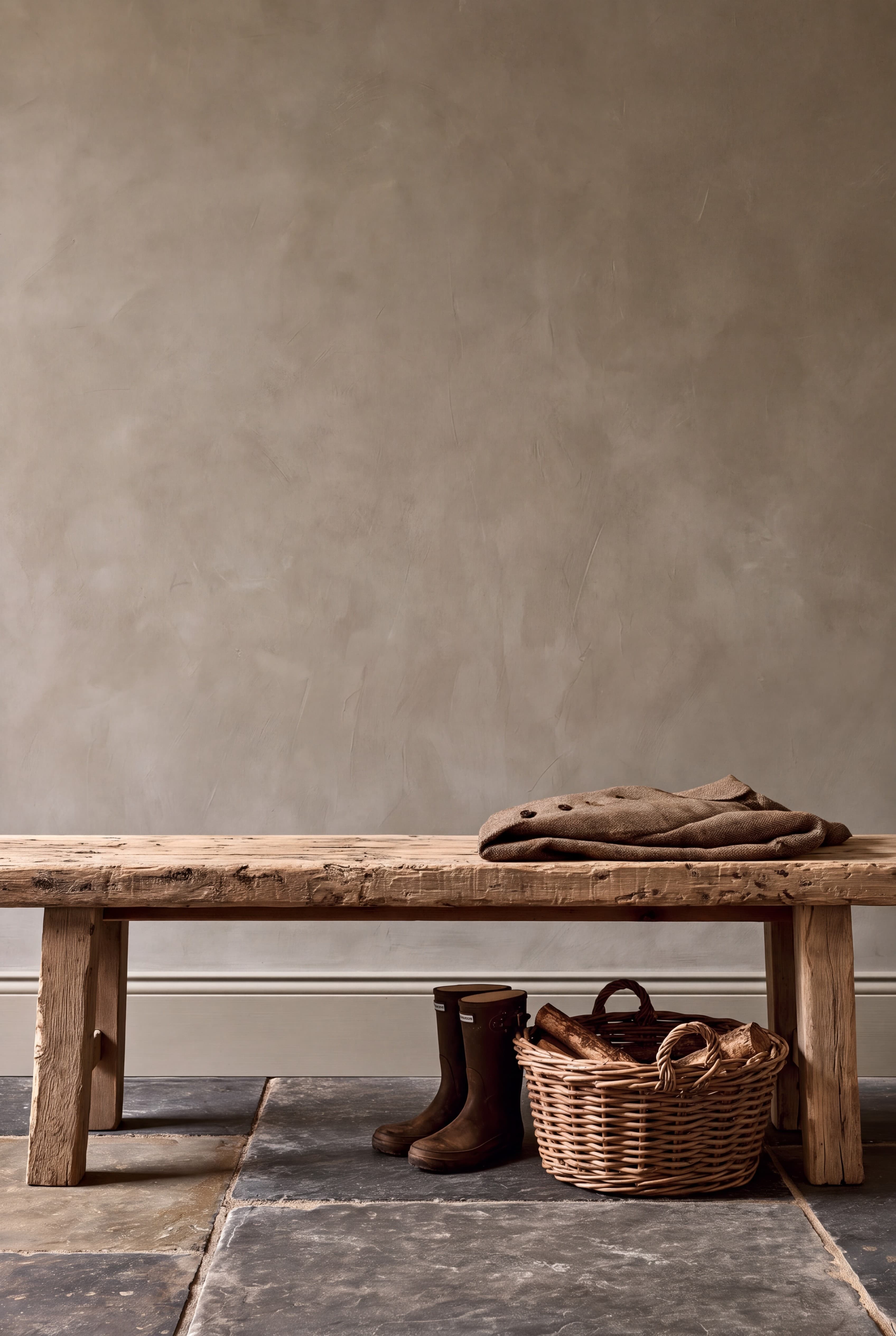 Country boot room with a warm greige wall, rustic pine bench, tweed jacket, wellington boots, and a basket of logs, ranked 3 among 11x17 poster mockups
