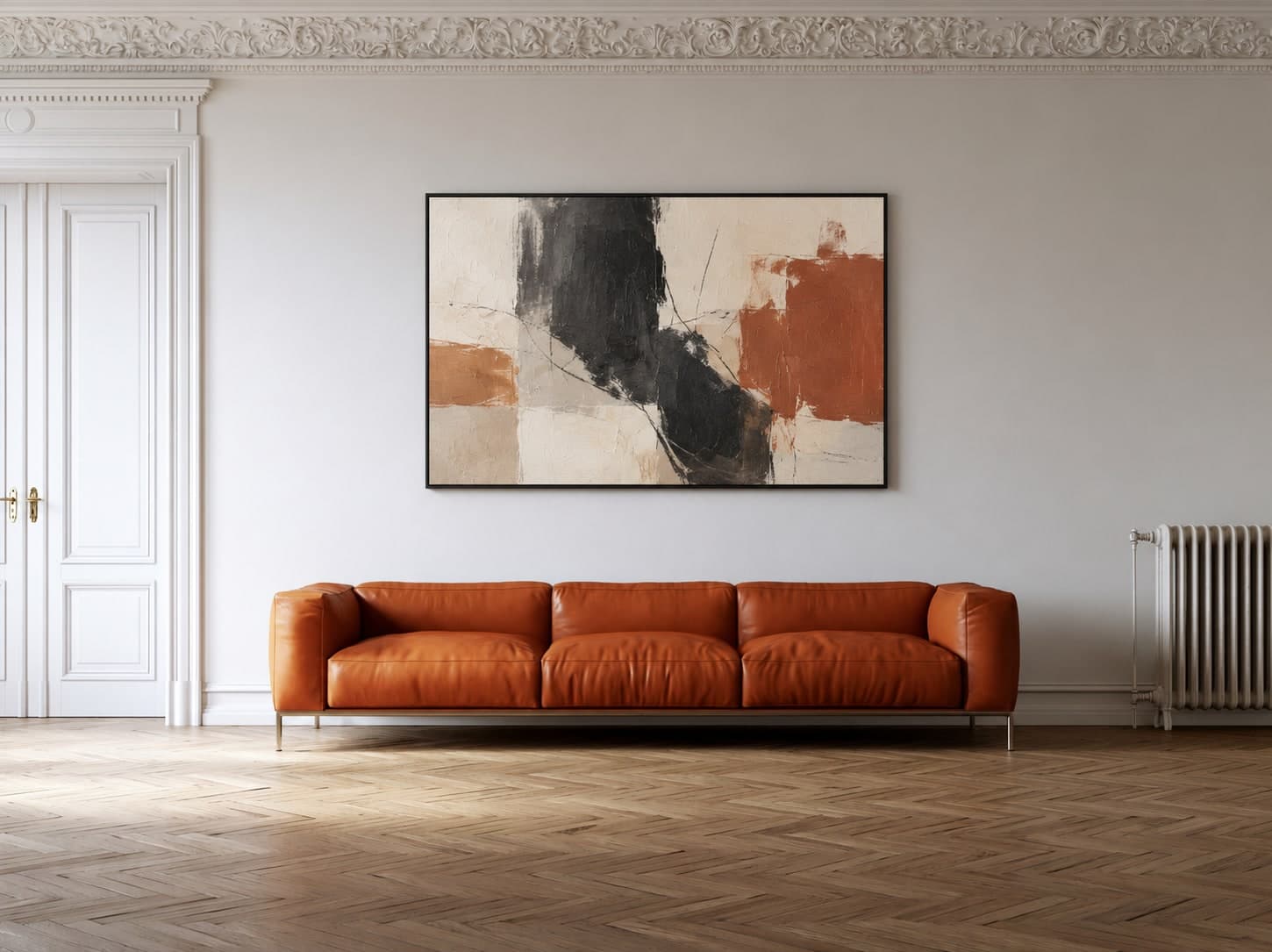 Cream, charcoal, and terracotta abstract art in a black frame above a cognac sofa in a Berlin Altbau apartment