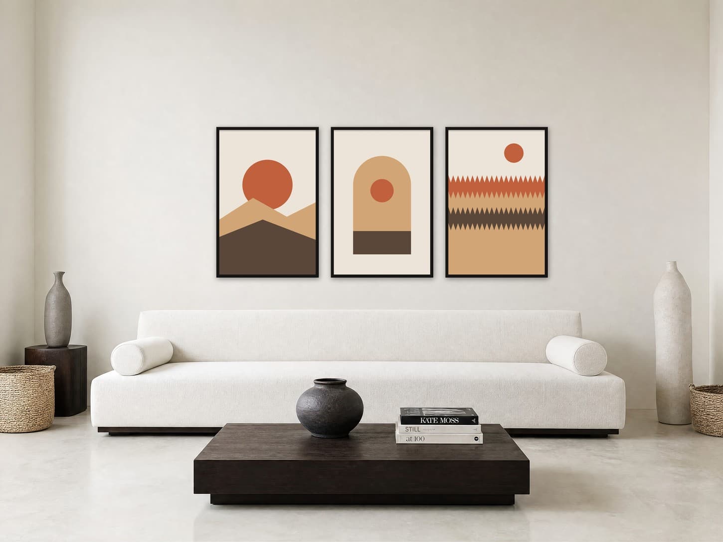 Three terracotta and sand geometric posters in thin black frames above a long white sofa