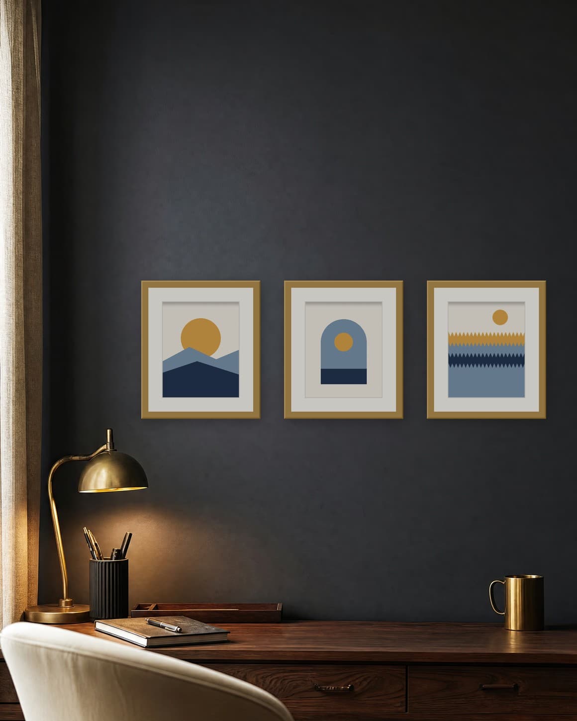 Three navy and gold matted prints in brass frames on a charcoal office wall above a walnut desk