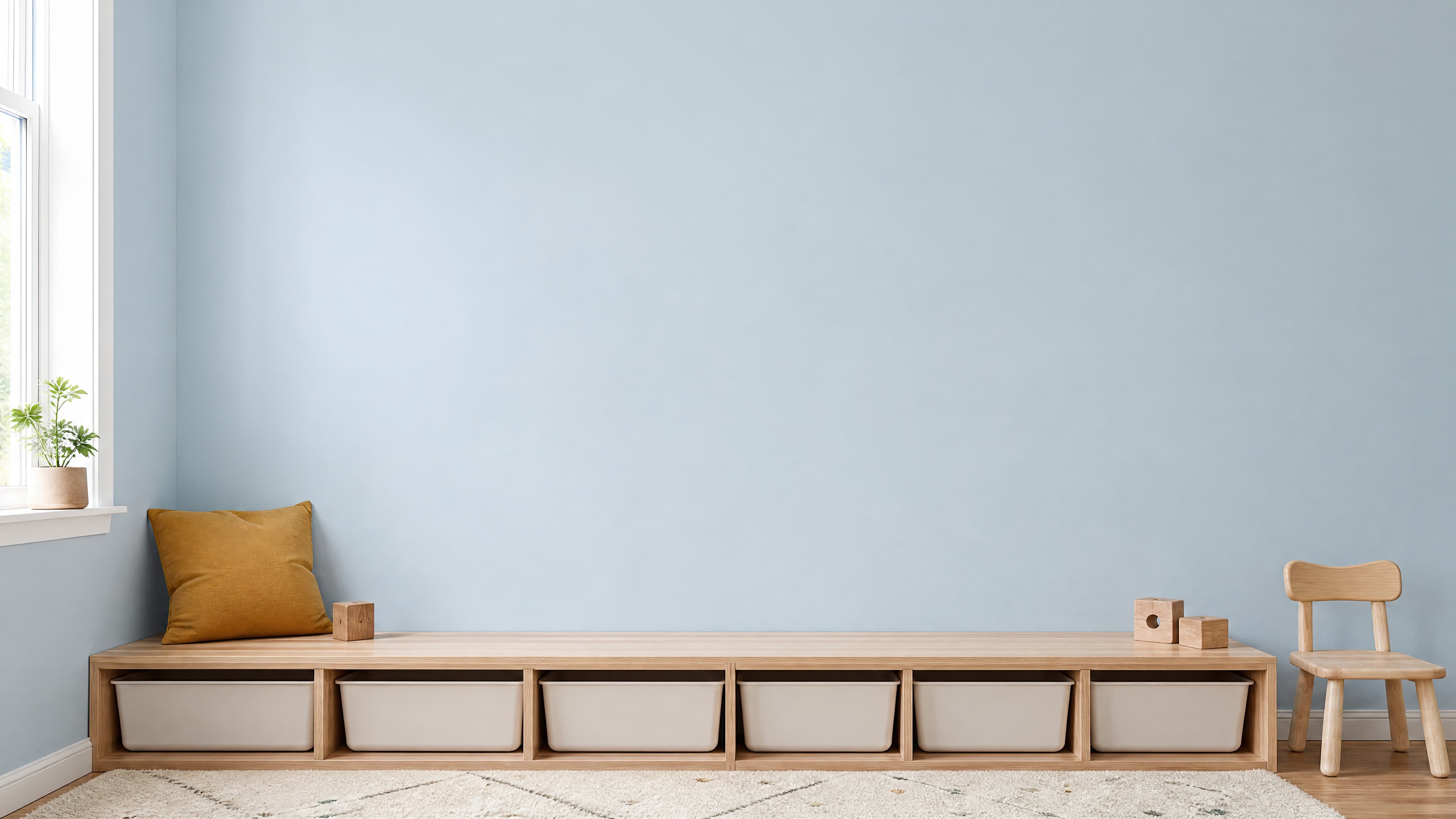 Bright Scandinavian kids room with an empty pale blue wall above a low wooden storage bench and small child-sized chair, ranked 10 among nursery mockups