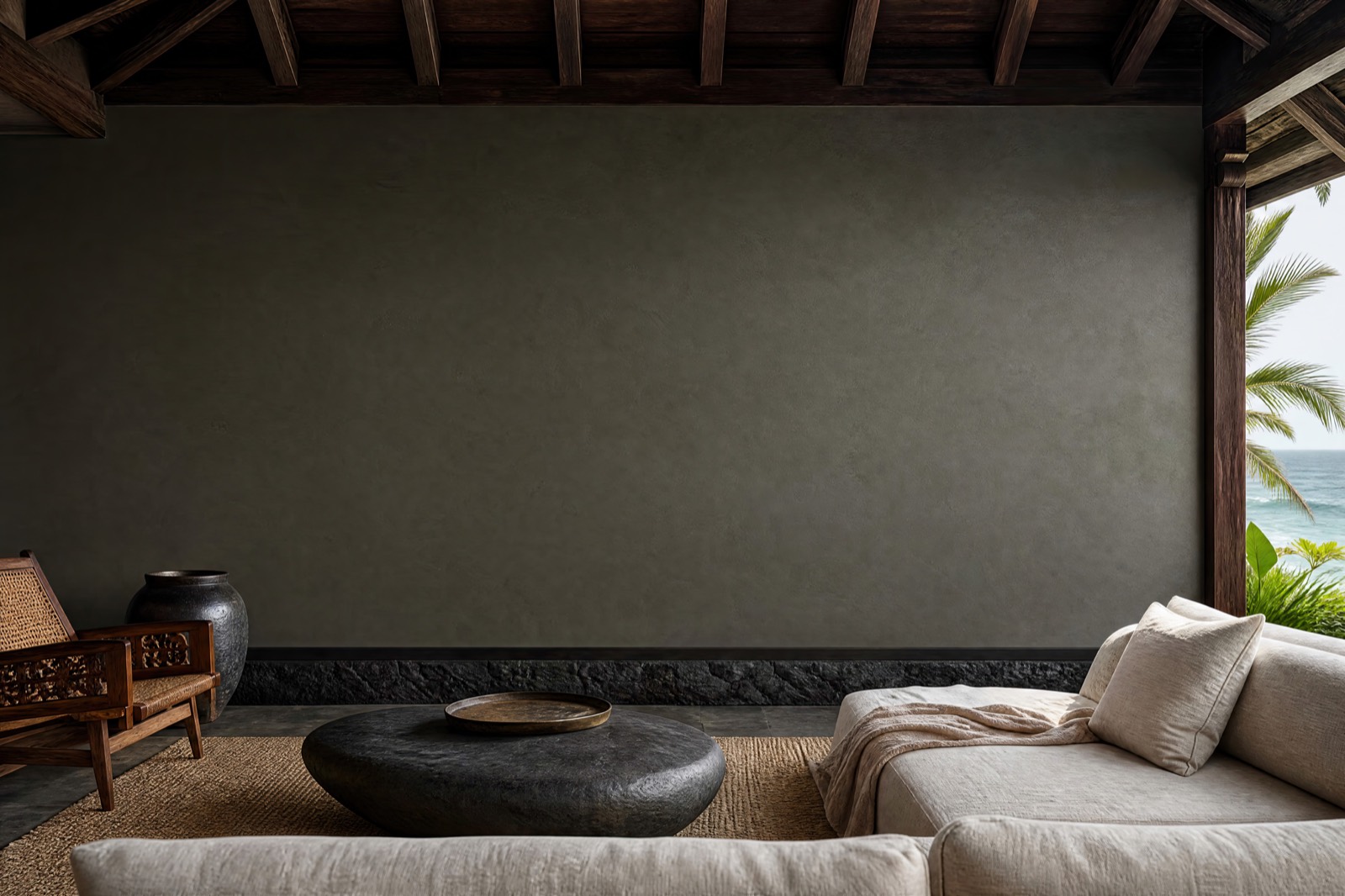 Smoky charcoal display wall and low linen seating in the open-air Balinese pavilion room